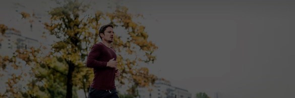 Man running near a tree with autumn leaves