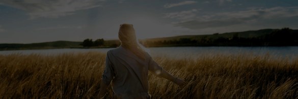 Woman in wheat field in the evening sun