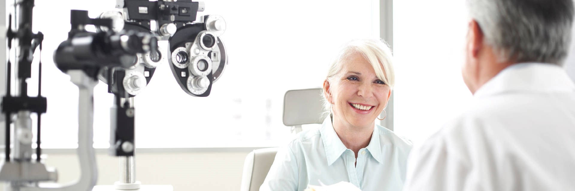 Woman and man in front of optometrist equiment