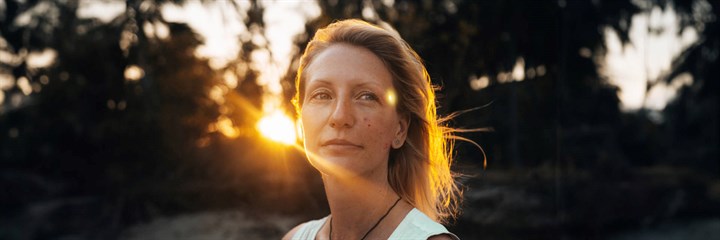 Woman with acne on her cheek in the sunshine