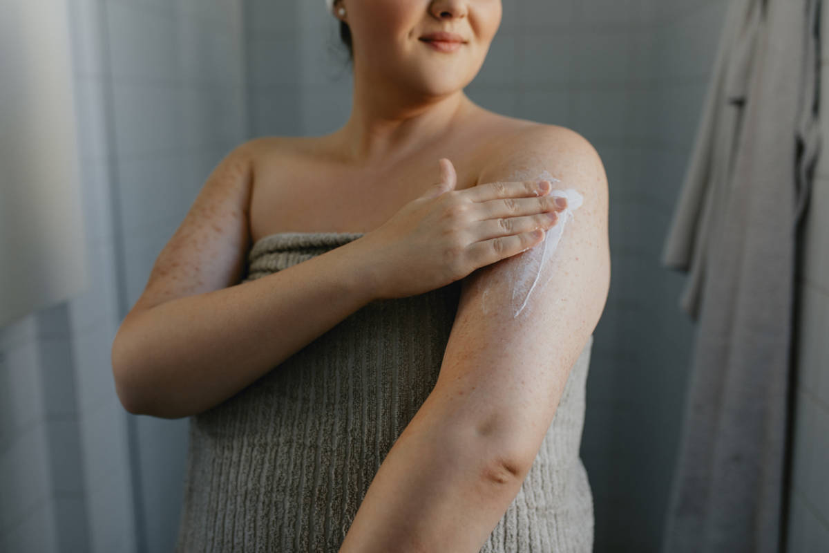 Woman moisturising after a shower