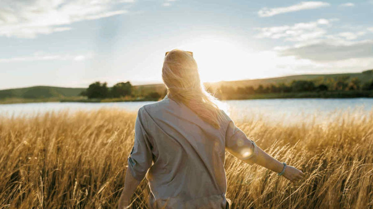 Woman in a wheat field in low sun