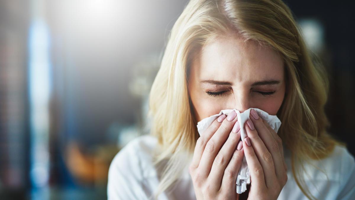 Young woman sneezing